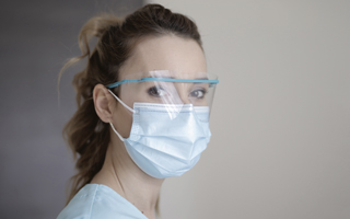 Medizinische Fachkraft, die Gesichtsschild und Schutzmaske trägt